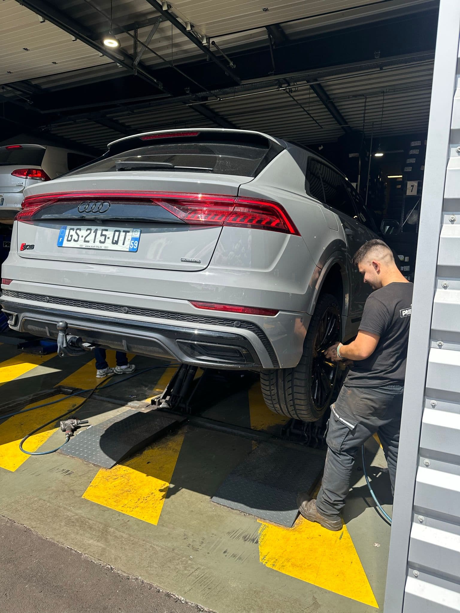 Montage pneu Audi Q8 sur pont elevateur par un technicien Pneu Station